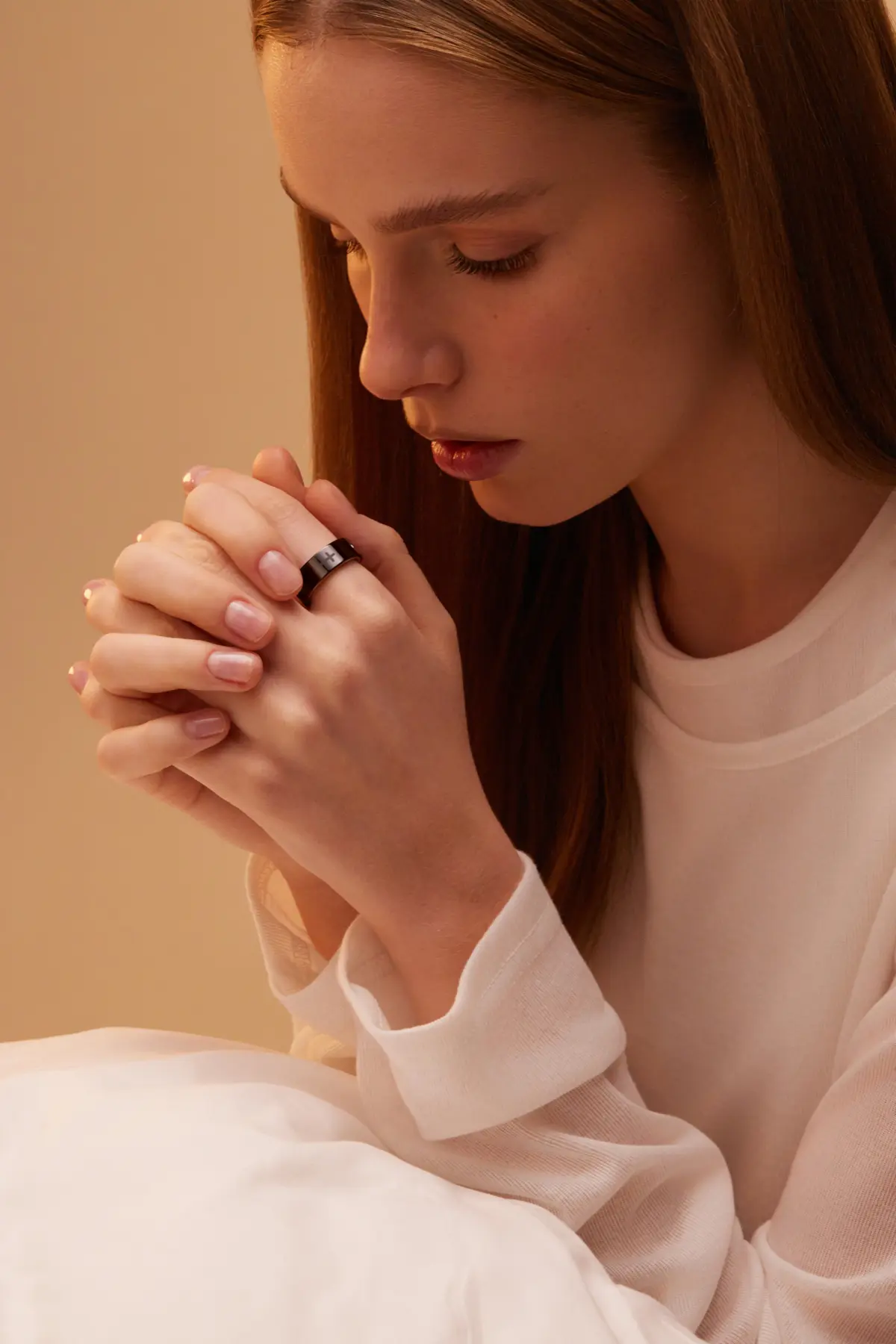 Woman praying with Bless Ring on her finger